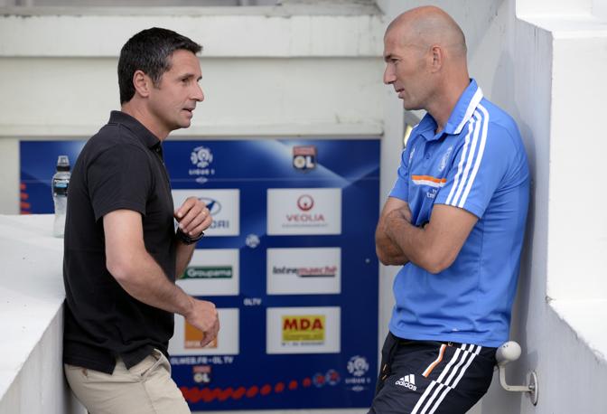 Zinedine Zidane, assistente di Ancelotti, parla con Remi Garde, tecnico del Lione. Afp